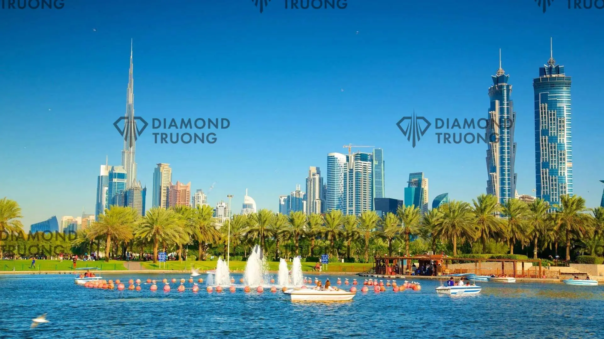 Safa Park's lake with fountains and pedal boats, the Burj Khalifa and Business Bay towers behind the palms