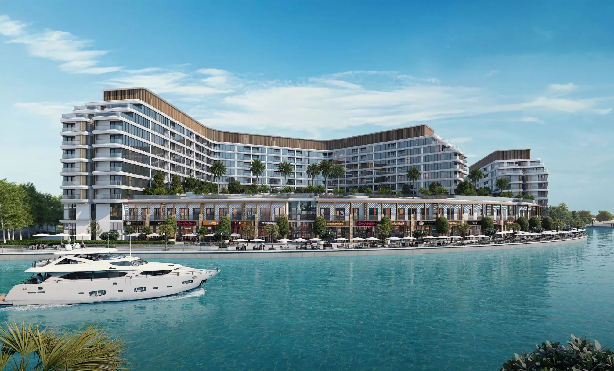 Render of a curved apartment block above a row of named shopfronts and café umbrellas on the canal, with a large yacht in front