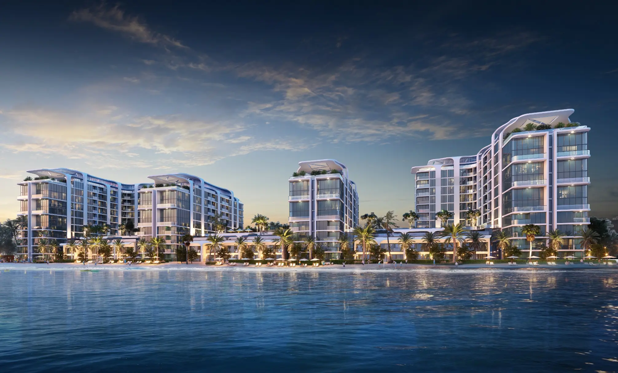 Render at dusk of Coastline's four white towers lit up behind palms and a low row of homes, seen across the lagoon