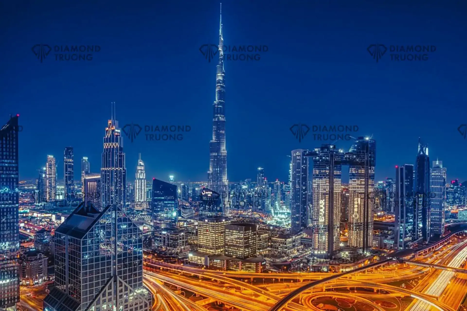 Downtown Dubai's towers and the Burj Khalifa at night, seen across a lit road interchange