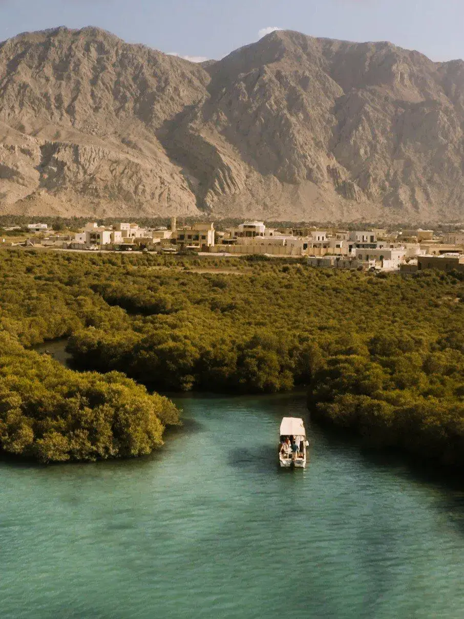 Boat navigating through a narrow river surrounded by tall buildings.