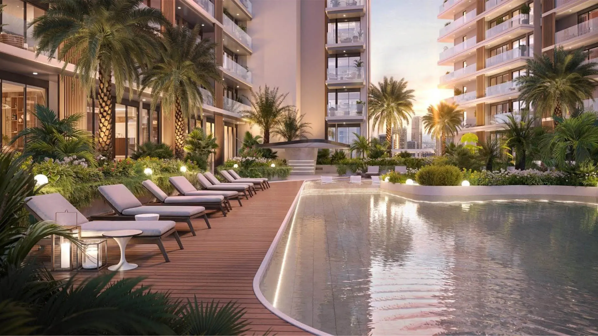 Ellington's render of The Hillgate in Dubai Silicon Oasis: a pool deck with loungers between apartment buildings at sunset