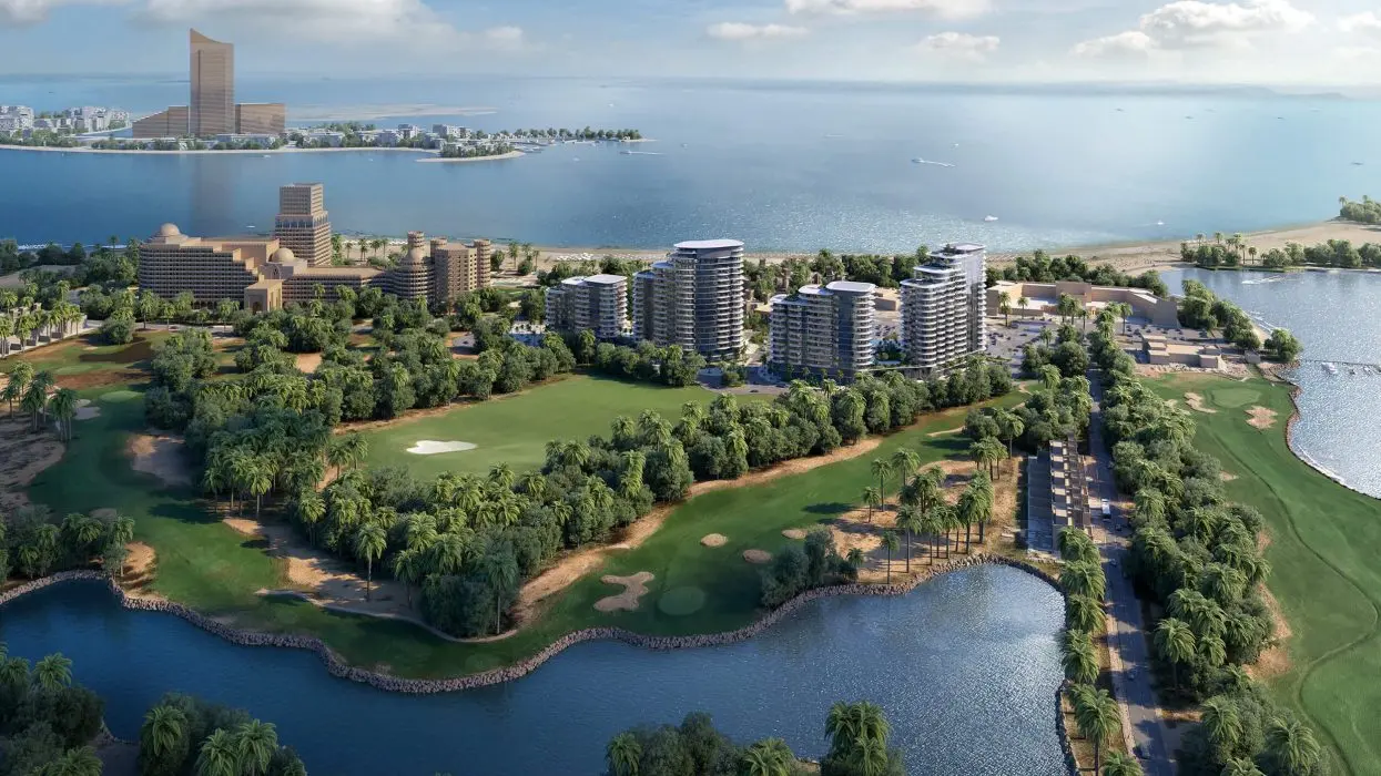 Aerial render of four towers with curved balconies beside a golf course and lakes, with the sea and a tall gold tower on an island beyond