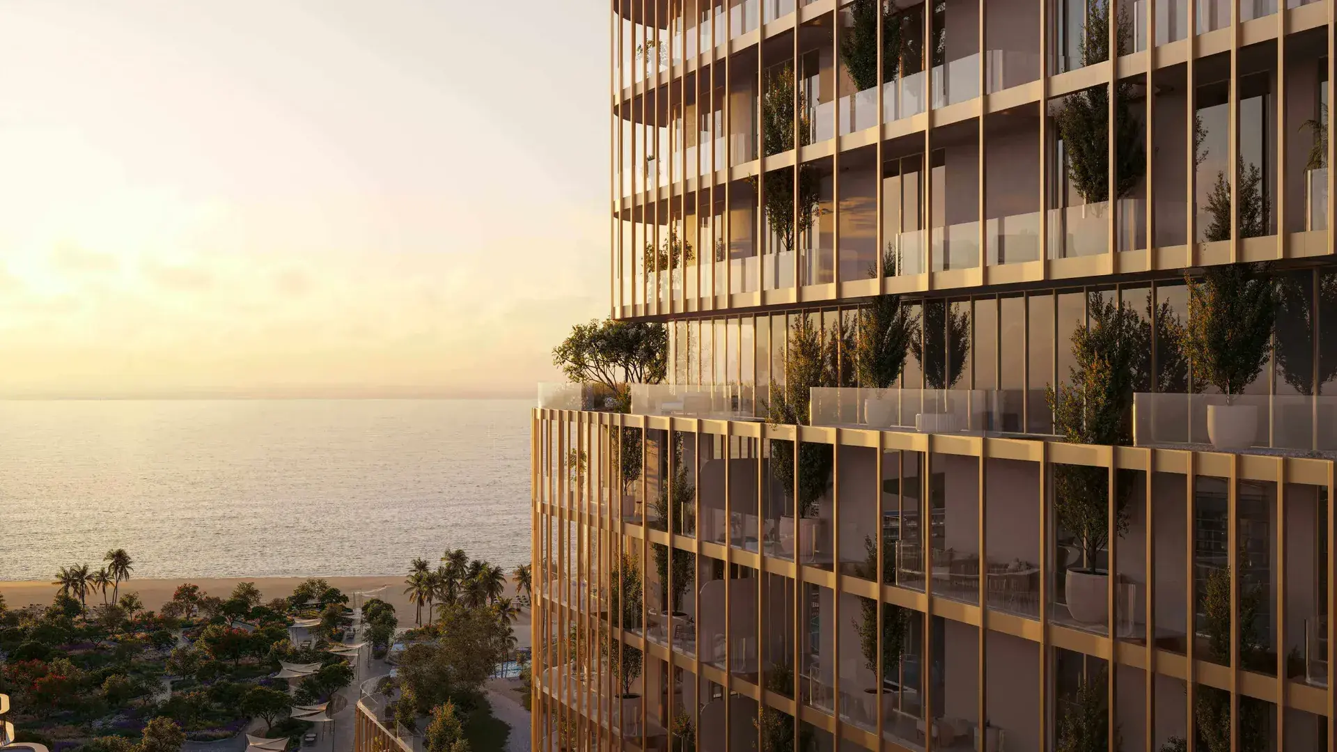 Render of a tower's corner at sunset, with planted balconies behind slim gold fins and the beach and sea below