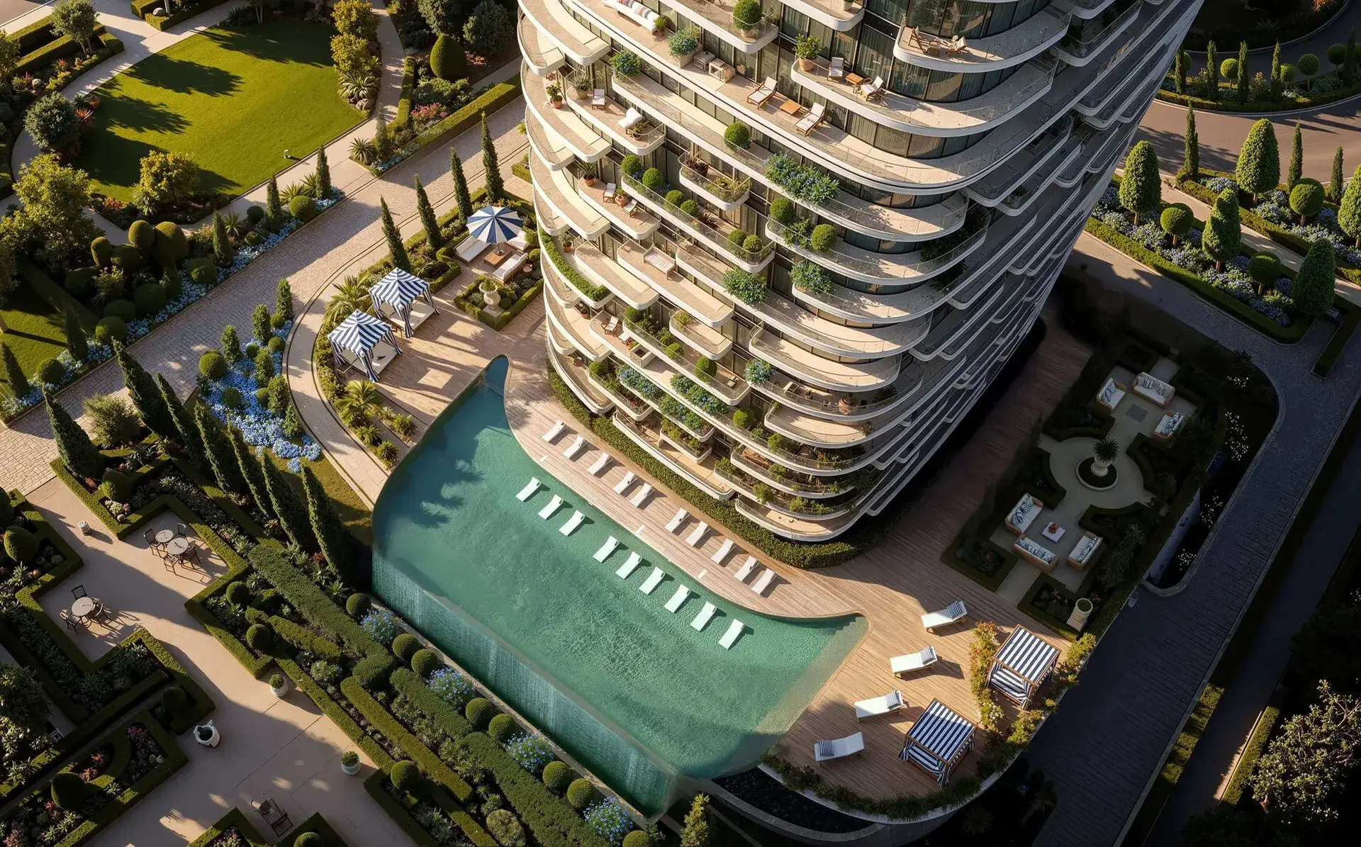 Aerial render of the tower's curved balconies above a long pool with loungers and striped cabanas, in formal hedged gardens