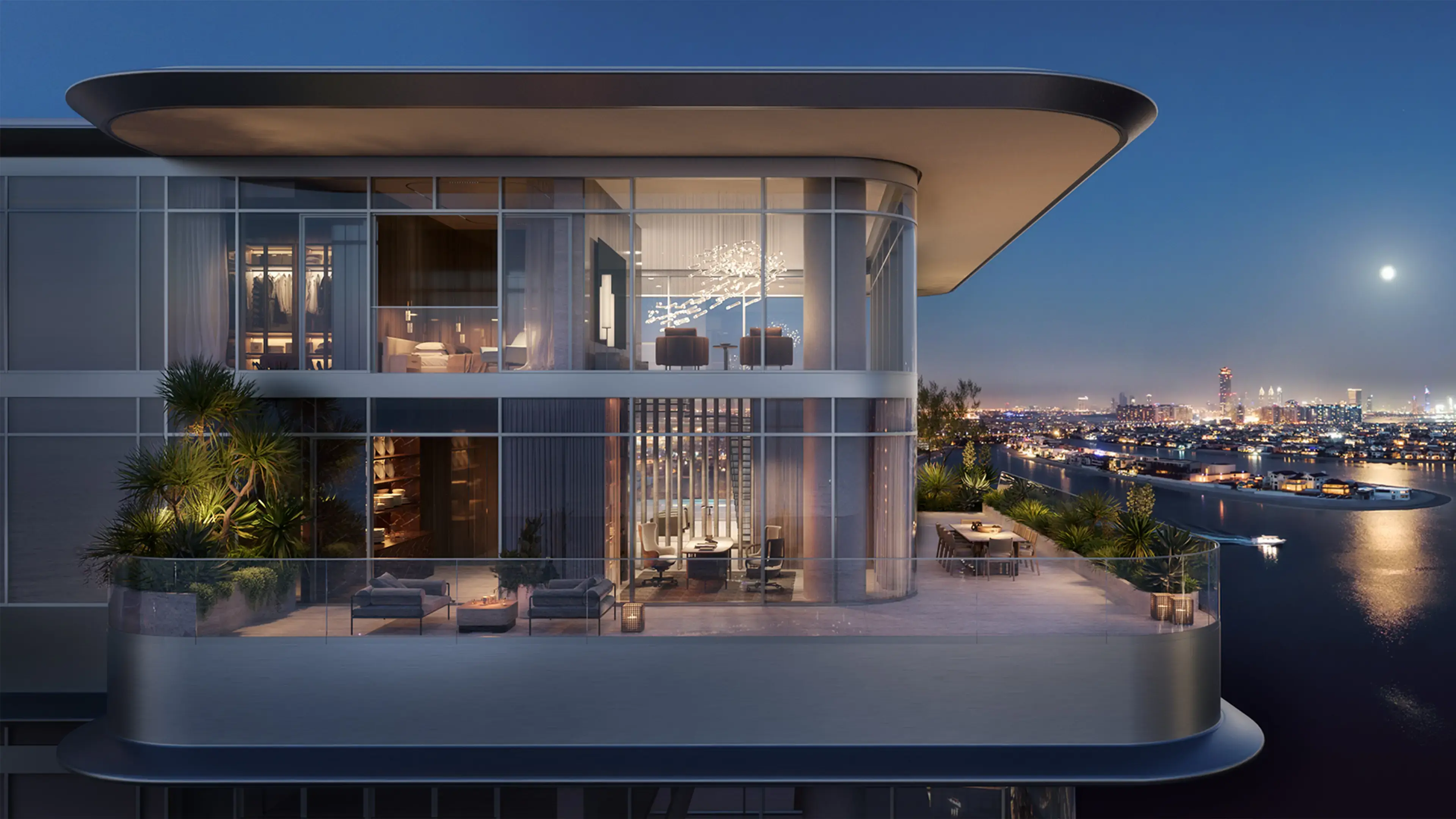 Render of a duplex at night, lit through two storeys of glass above a terrace with sofas and a dining table, the Palm's lights beyond