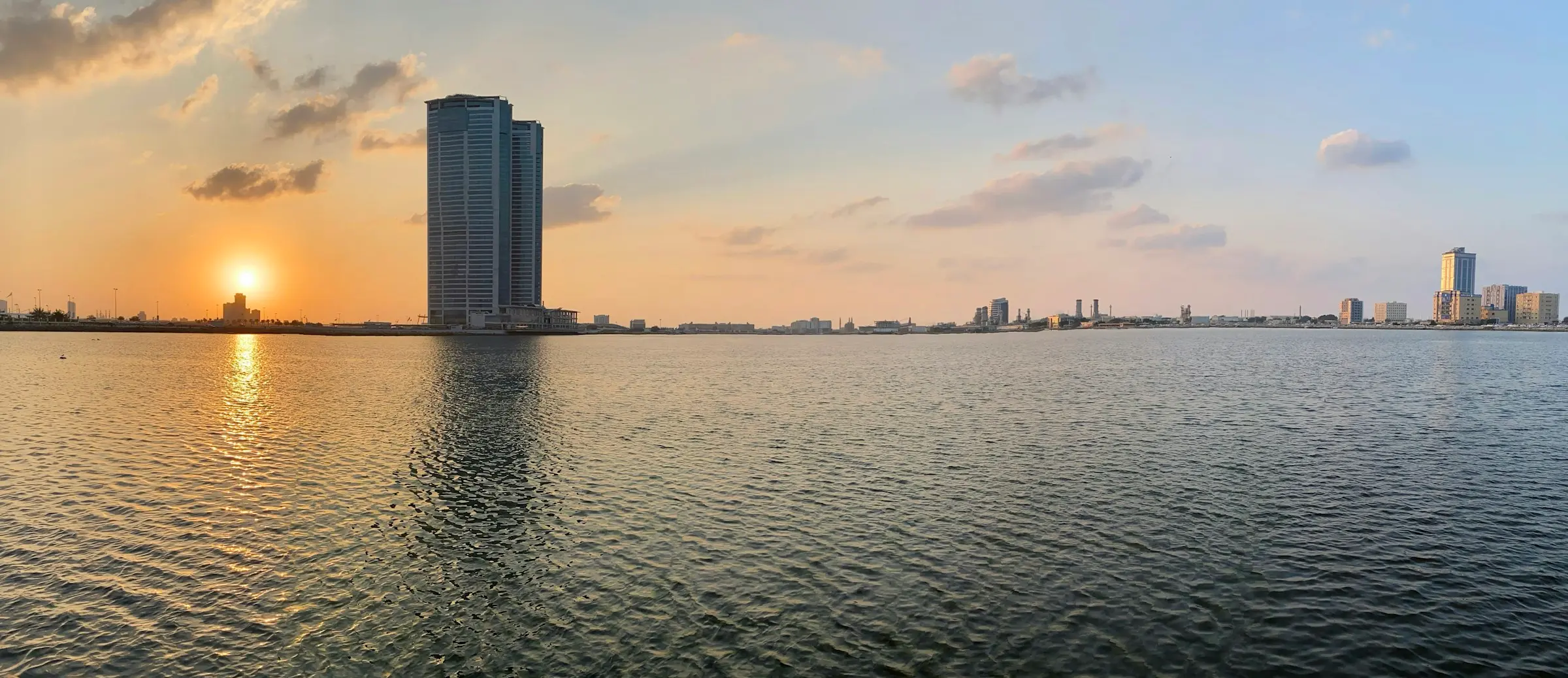 Sunset over the water at Al Mairid, Ras Al Khaimah, with towers on the shoreline