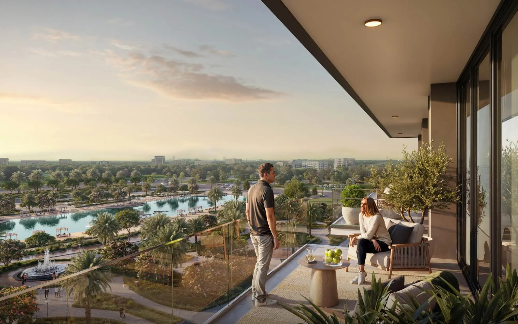 Render of a couple on a balcony at sunset, looking over a lagoon, a fountain and parkland