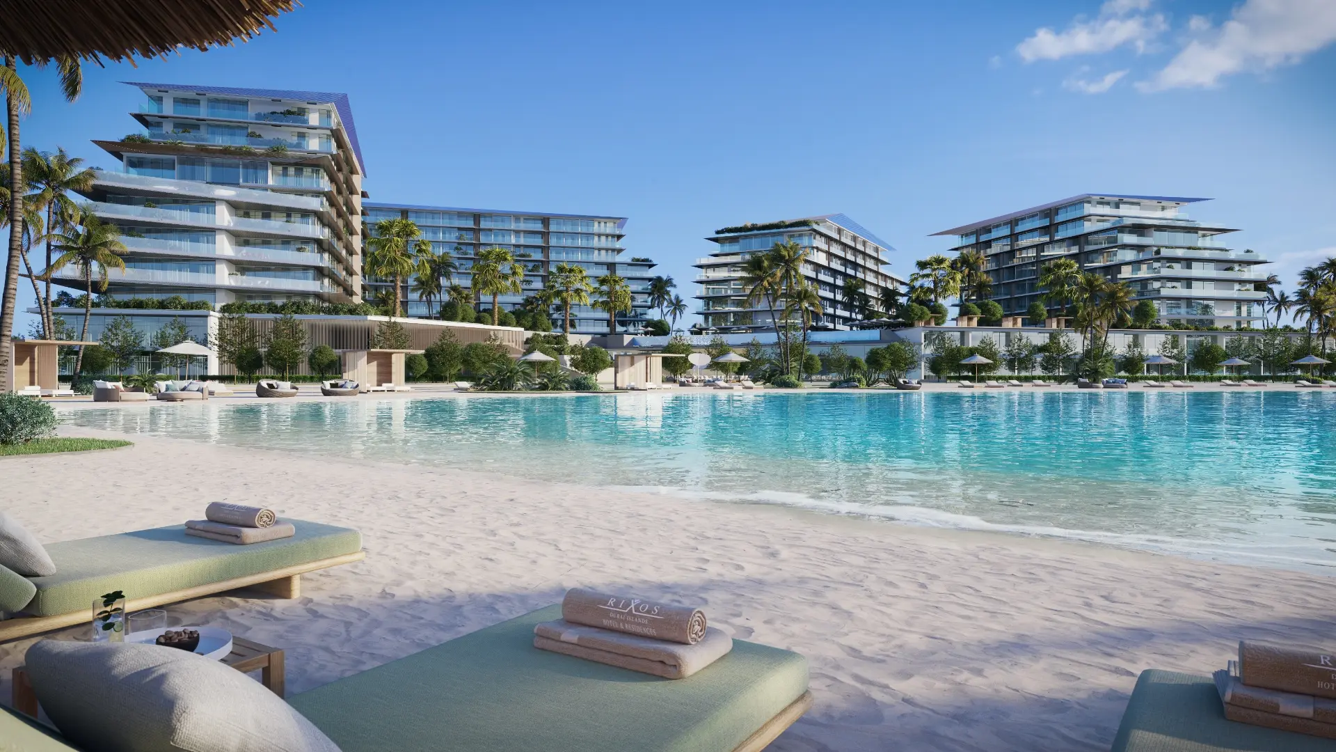 Render of beach loungers with Rixos-branded towels beside a lagoon, with four mid-rise buildings behind the palms