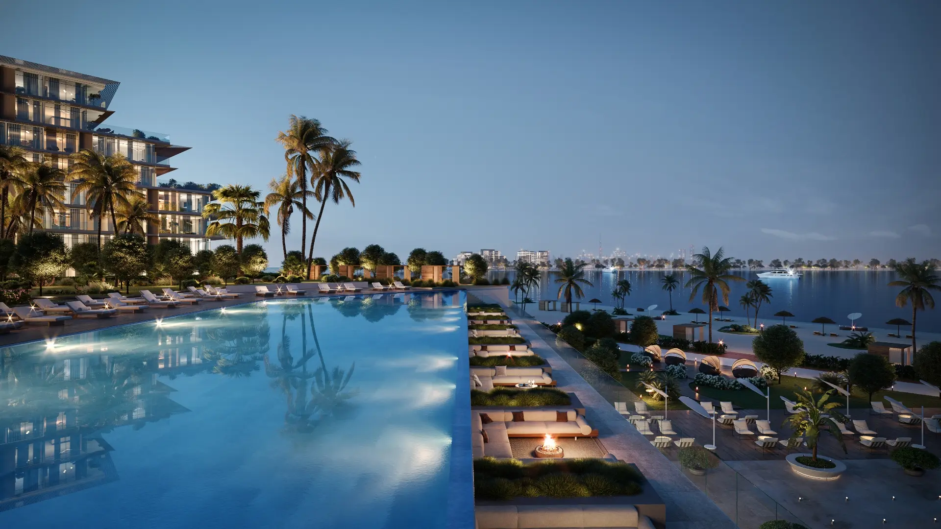 Render at dusk of a long infinity pool beside lounges with fire pits, a lit beach and the city skyline across the water