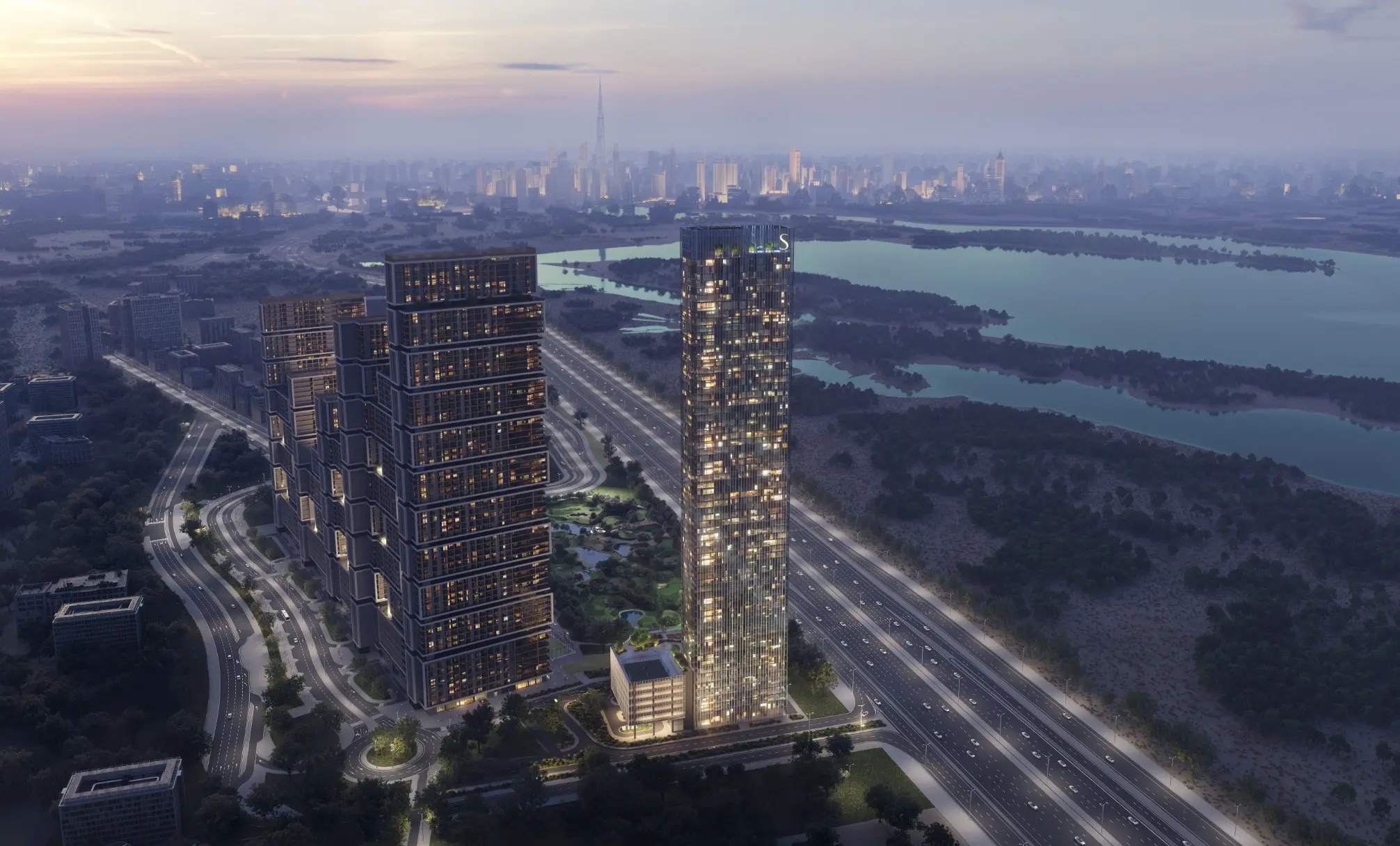 Dusk aerial render of a slender glass tower beside Ras Al Khor Road, stepped towers to its left, the wetland to its right and Downtown behind